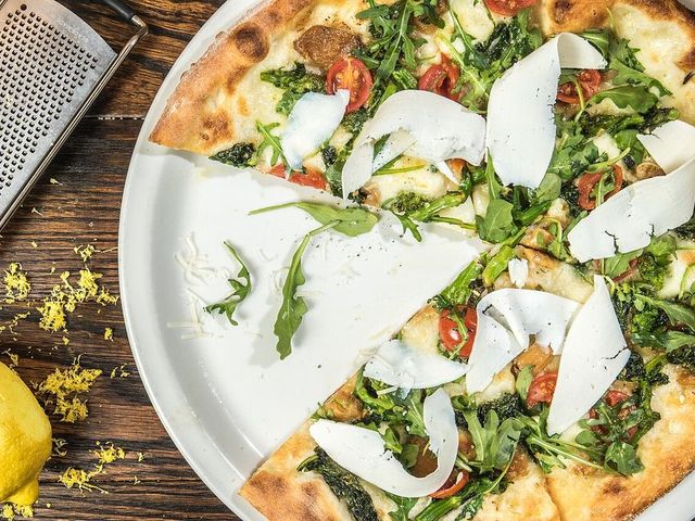 Pizza com rúcula e lascas de parmesão
